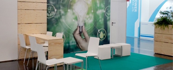 Lounge für electronica 2024 mit Hochtisch, Stühlen und Hockern, Großflächengrafik mit Glühbirne